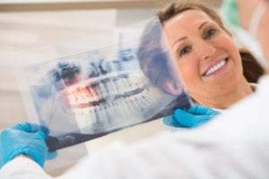 Dentist With Teeth X-ray In Front Of Woman