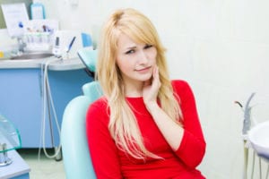 portrait sad, young girl, woman with painful tooth, ache in medical office siting in chair, isolated dentist clinic